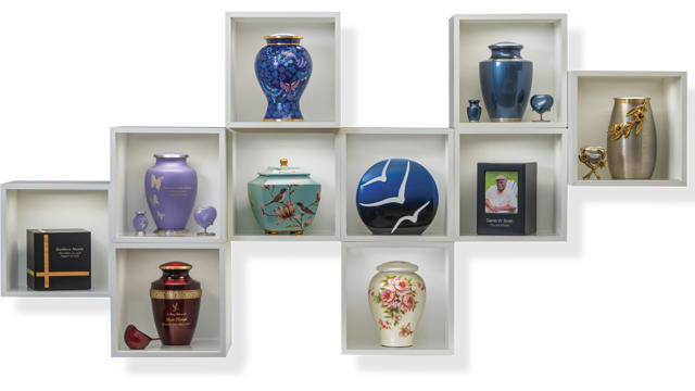 A collection of urns and memorials displayed in cube shelving